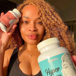 Woman holding two supplement bottles labeled 'Acne Cleanse' and 'Hyperpigmentation cleanse' in a close-up shot.